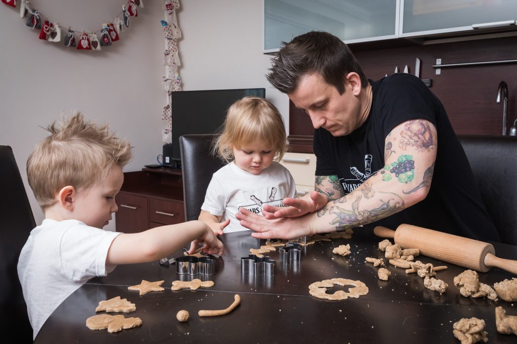 Tėtis su mažais vaikais kepa sausainius
