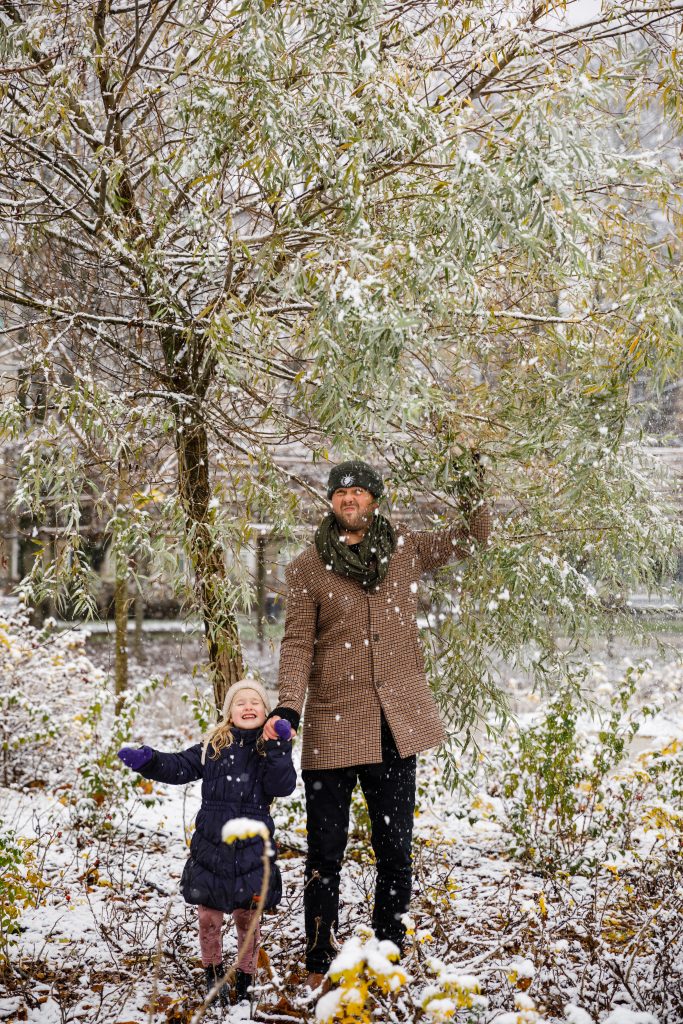 Dad with daughter under snowy tree
