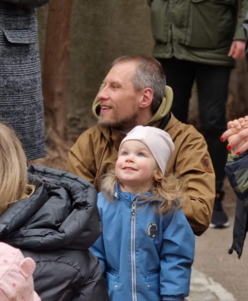 Tėtos su penkiamete dukrele minioje žmonių šypsosi
